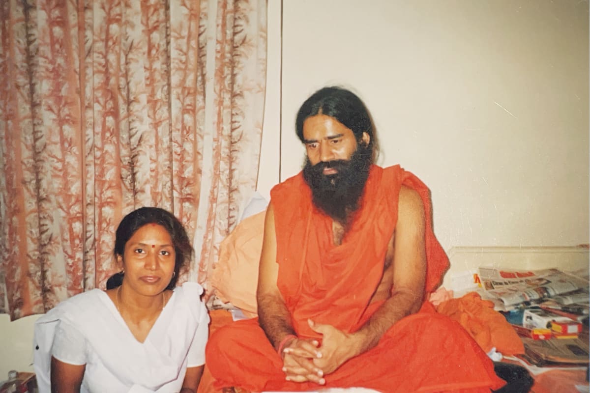 A young Dr. Seema Saxena seated beside Swami Ramdev